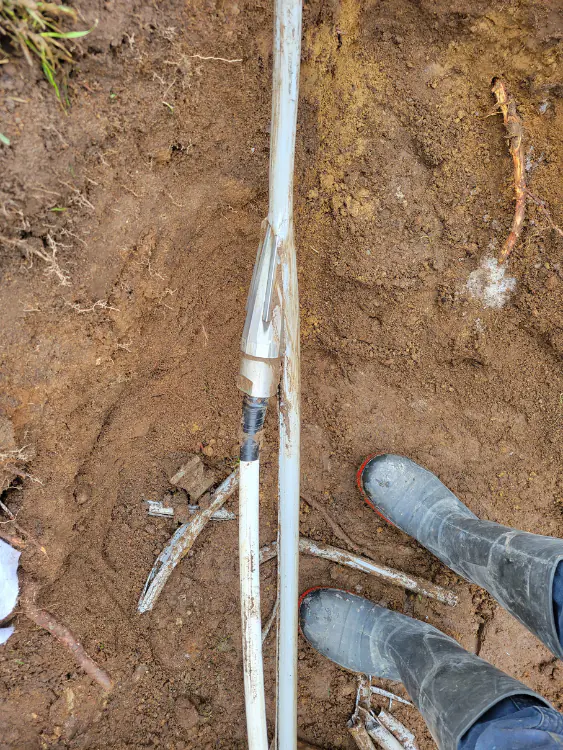 Poly B Pipes White plastic supply pipe run in an open trench