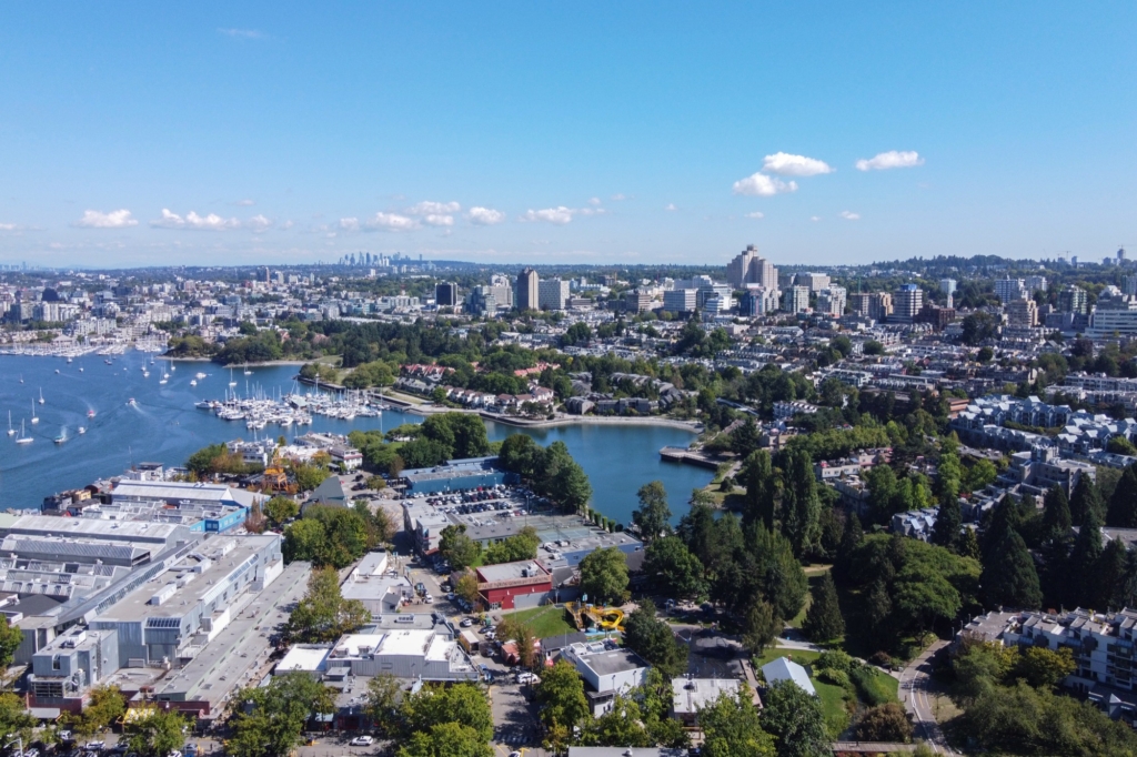 Aerial view over Granville Island and the south shore of False Creek, with townhouses and low rise apartment blocks climbing the slope toward Broadway, in Fairview, Vancouver