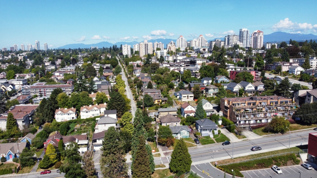 New Westminster Aerial view over New Westminster near Queen's Avenue and Ninth Street, showing older detached houses, low-rise apartments, mature boulevard trees and the sloping street grid running up to the Uptown towers in New Westminster