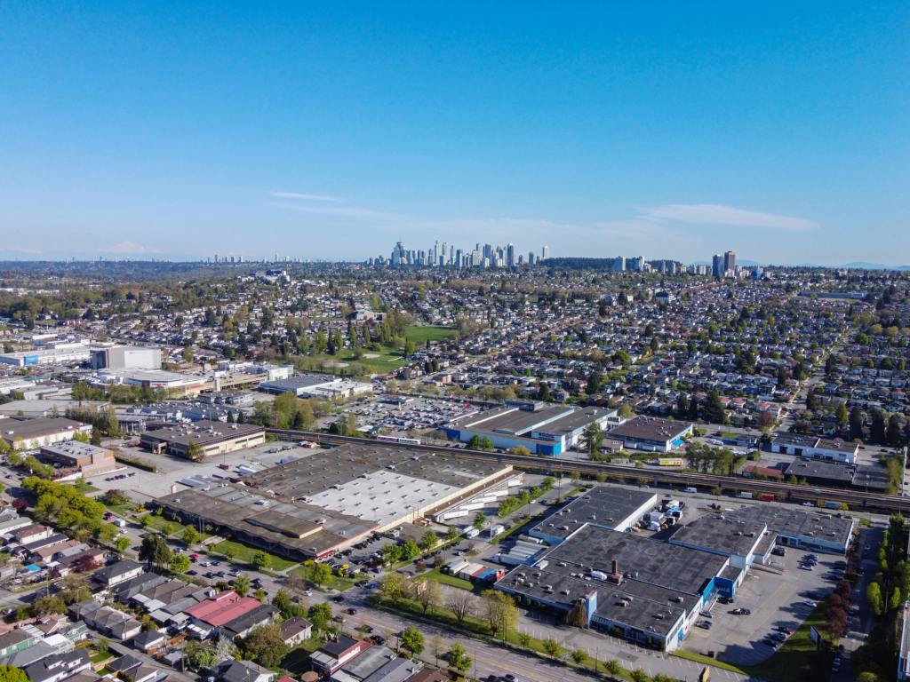 Renfrew Heights, Vancouver Aerial view over blocks of single-family houses and tree-lined streets sloping down to a rail corridor and low industrial buildings in Renfrew Heights, Vancouver