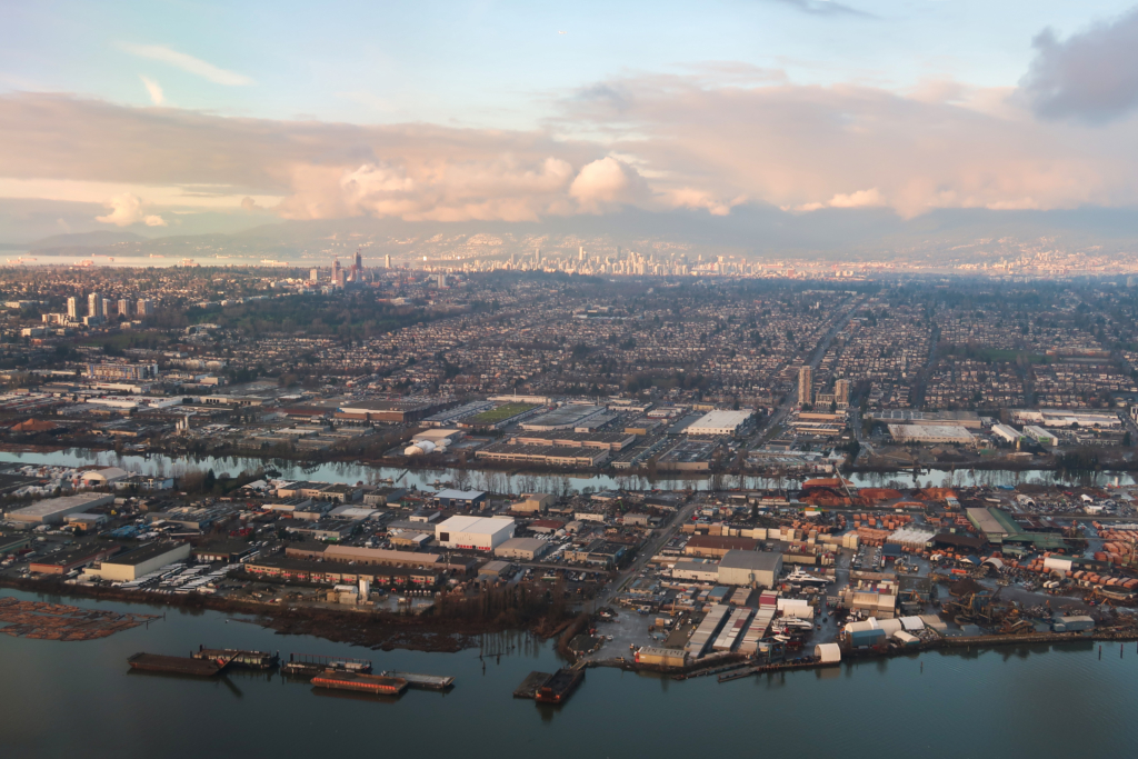 Sunset, Vancouver Aerial view north across the Fraser River over the industrial strip along South East Marine Drive and the grid of single family blocks in Sunset, Vancouver