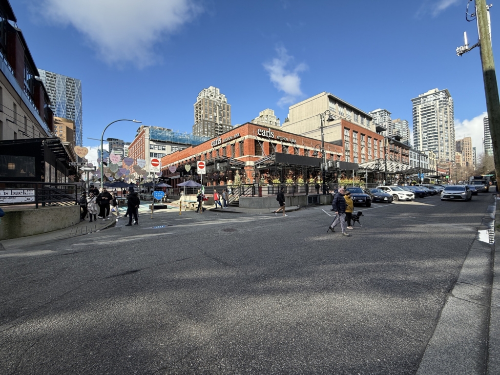 Yaletown, Vancouver Red brick warehouse buildings and street level patios at Mainland Street and Helmcken Street, with condo towers behind, in Yaletown, Vancouver